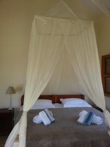 une chambre avec un lit à baldaquin dans l'établissement Villas Coccoloba & Jacaranda, à Capesterre 17 autres photos