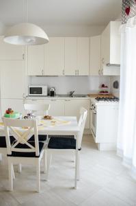 a white kitchen with a white table and chairs at Cheap & Chic Thermae&Relax in Abano Terme