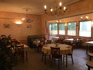 um restaurante com mesas e cadeiras e um piano em Hotel Fama em Hódmezővásárhely