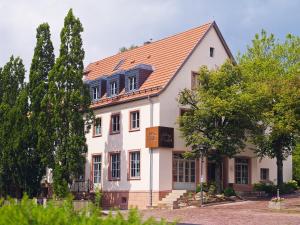 a white house with an orange roof at Auberge de Temple in Johannesberg