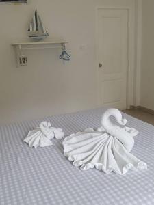 uma cama com dois cisnes feitos de toalhas em Charlie's Bungalows em Ko Si Chang