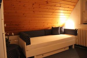 a bed in a room with a wooden wall at Haus Kleemann in Norderney