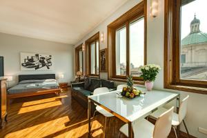 ein Wohnzimmer mit einem Tisch und einem Sofa in der Unterkunft BnButler - Duomo Apartment - Galleria Unione in Mailand