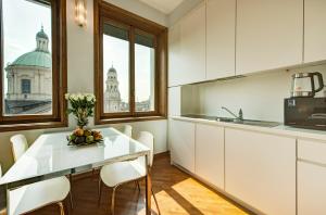 a kitchen with a table with a bowl of fruit on it at BnButler - Duomo Apartment - Galleria Unione in Milan