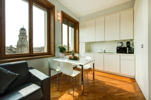 ミラノにあるBnButler - Duomo Apartment - Galleria Unioneのキッチン、リビングルーム(白いテーブル、椅子付)