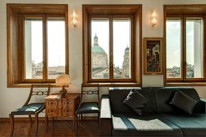 ein Wohnzimmer mit einem Sofa und einigen Fenstern in der Unterkunft BnButler - Duomo Apartment - Galleria Unione in Mailand