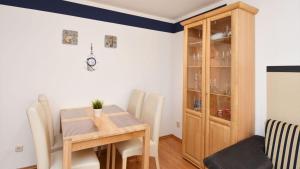 a dining room with a table and chairs and a cabinet at Ferienwohnung-Ruegenzauber in Baabe