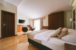 a bedroom with a large bed and a desk at Hotel Jana in Međugorje