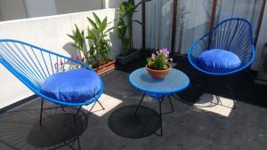 3 sillas azules y una mesa en el balcón en Las Frambuesas en Viedma