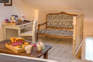 una habitación con una silla con estampado de cebra y una mesa en The Originals Boutique, Clair Hôtel, Martigues (Inter-Hotel), en Martigues