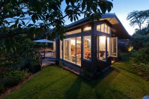 a small house with a lot of windows at Stone Store Lodge in Kerikeri