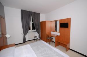 a bedroom with a bed and a desk and a window at Porta del Parco in Camogli