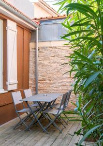 a picnic table and two chairs on a patio at Bordo'Appart Hoya Bella in Arcachon