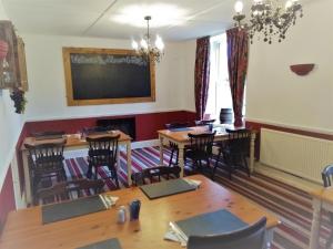 a dining room with tables and chairs and a chalkboard at Llanerch Inn in Llandrindod Wells