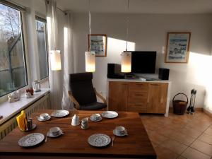 ein Wohnzimmer mit einem Tisch und einem TV in der Unterkunft Whg Suedblick auf Föhr in Goting