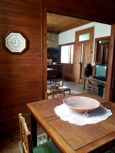 a dining room with a table and a clock on the wall at Casa da Vila in Penamacor