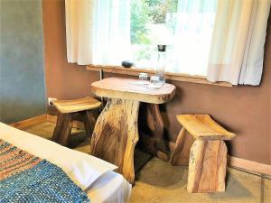 una habitación con una mesa y dos taburetes junto a una ventana en Elementos Eco Lodge, en Pucón