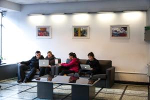 a group of people sitting on a couch with laptops at Hotel Premier Bariloche in San Carlos de Bariloche