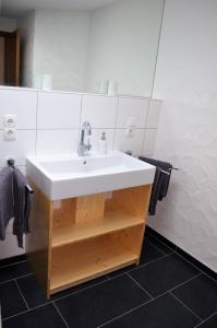 a bathroom with a white sink and a mirror at Beim Hooch "Schindelloft" in Brücktal +11 photos