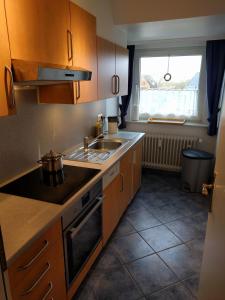 a kitchen with wooden cabinets and a sink and a window at Whg Suedblick auf Föhr in Goting