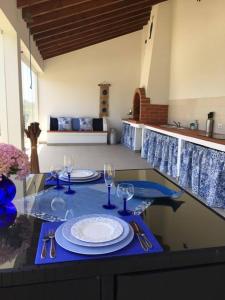 stół z talerzami i kieliszkami do wina na górze w obiekcie Casa da Samouqueira w mieście Rogil