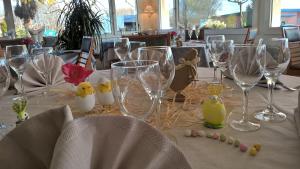 - une table avec des verres à vin vides et des fleurs dans l'établissement Hôtel Restaurant Alios, à Bas-Mauco