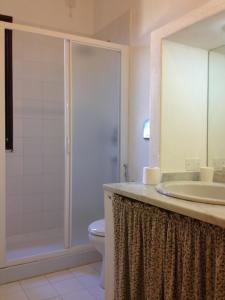 een badkamer met een douche, een wastafel en een toilet bij Al Sandalyon in Quartu SantʼElena