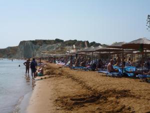 a group of people on a beach with umbrellas at Gouna's Aparts in Xi