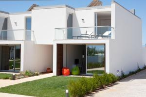 a white house with a balcony with a lawn at Seasagres - Design Villas in Sagres