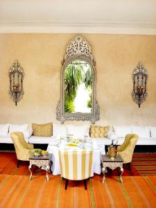 a living room with a white couch and a mirror at Riad L'H&ocirc;tel Marrakech in Marrakesh