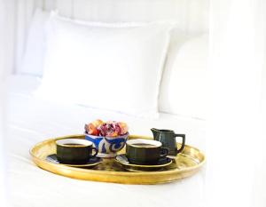 a tray with two coffee cups and a bowl of fruit at Riad L'H&ocirc;tel Marrakech in Marrakesh