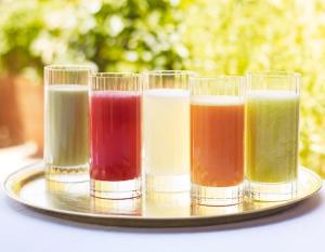 a tray with four glasses of different colored liquids at Riad L'Hôtel Marrakech in Marrakesh