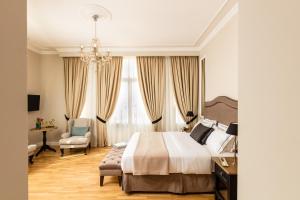 a bedroom with a bed and a desk and a chair at Athens Mansion Luxury Suites in Athens