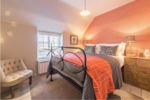 a bedroom with a bed and a chair and a window at No33 THORNHAM BOUTIQUE COTTAGE 3 in Thornham