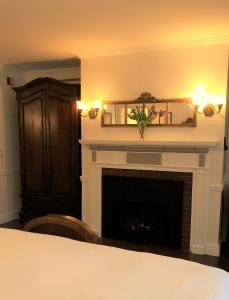 a living room with a fireplace and a bed at Ivy Manor Inn Village Center in Bar Harbor