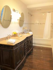 a bathroom with two sinks and a large mirror at Ivy Manor Inn Village Center in Bar Harbor