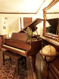 a piano sitting on top of a wooden table in a living room at Ivy Manor Inn Village Center in Bar Harbor
