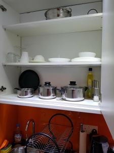 a kitchen shelf with pots and pans on it at Oak House in London