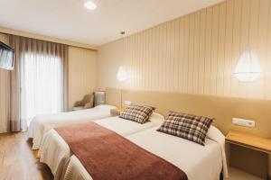 a hotel room with two beds and a window at Hotel Catalunya Ribes de Freser in Ribes de Freser +82 photos