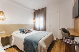 a hotel room with a bed and a desk at Hotel Catalunya Ribes de Freser in Ribes de Freser