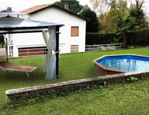 una piscina in un cortile con ombrellone di Villa Lina a Ranco