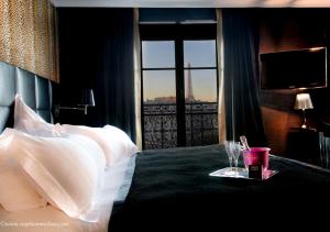 a bedroom with a bed with a view of a city at First Hotel Paris Tour Eiffel in Paris