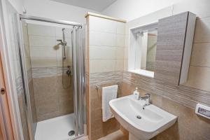W łazience znajduje się umywalka i prysznic. w obiekcie B&B Acquachiara w mieście Roccella Ionica