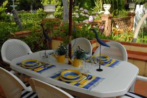 einem weißen Tisch mit Stühlen und einem blauen und gelben Tischtuch in der Unterkunft Quinta de Coalhos TH in Abrantes