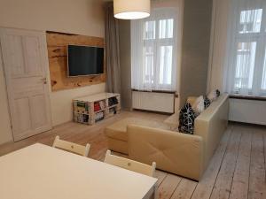 a living room with a couch and a tv at Apartament Zwycięstwa in Gliwice