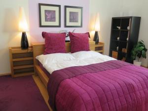 a bedroom with a large bed with a purple blanket at Apartmán Penzák in Vysoké Tatry