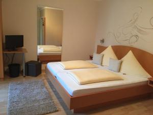 ein Schlafzimmer mit einem großen Bett und einem TV in der Unterkunft Pension Wagner in Ingolstadt