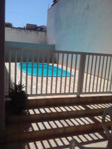 einen Zaun mit Pool dahinter in der Unterkunft Apartamento 3 quartos próximo a Praia Grande com ar condicionado in Ubatuba