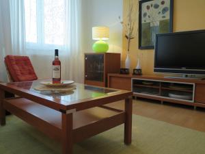 Sala de estar con una botella de vino en una mesa de centro en Apartmán Penzák, en Vysoké Tatry