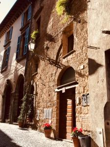 un bâtiment en pierre avec des plantes en pot dans une rue dans l'établissement B&B La Casa Di Tufo, à Orvieto